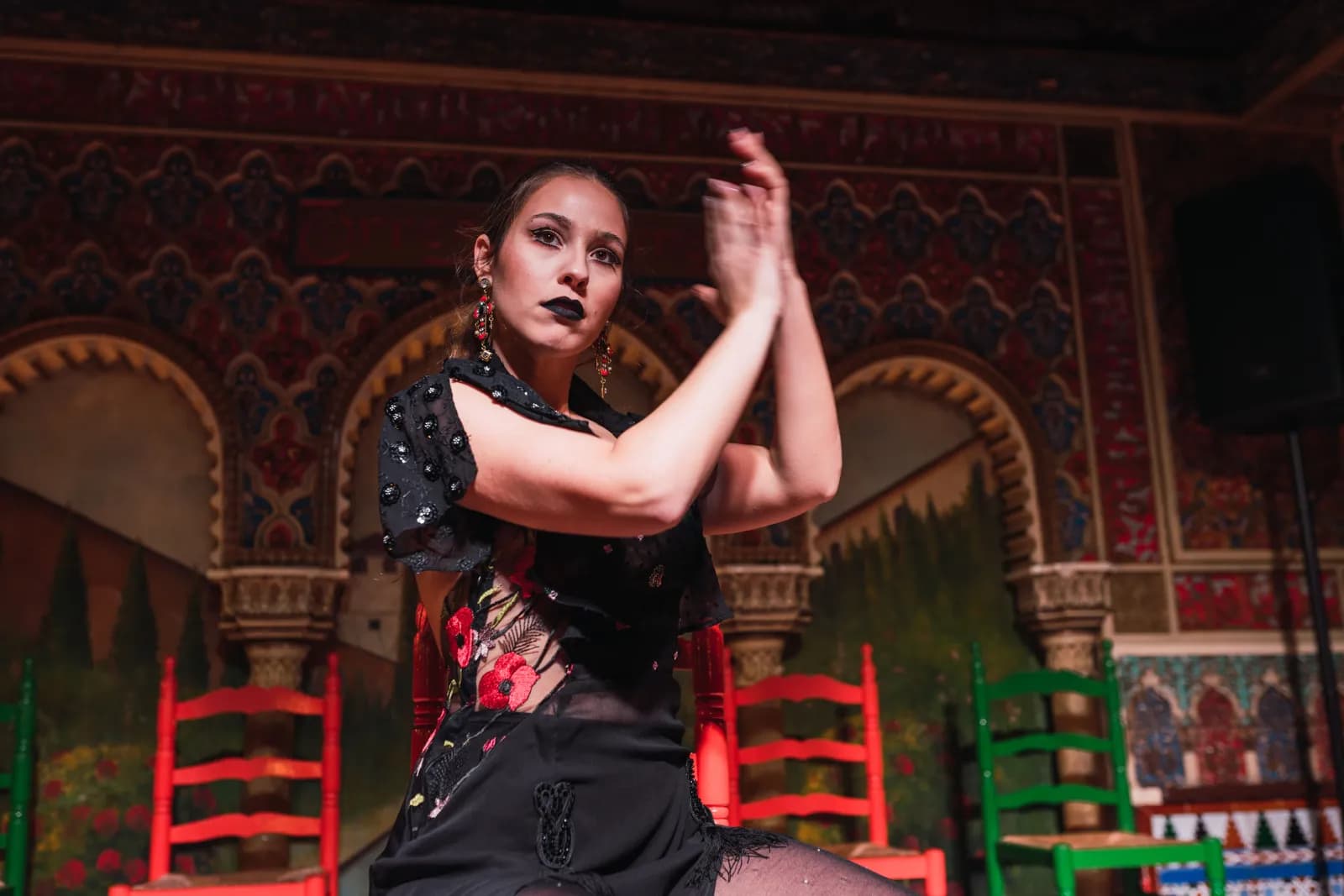 Bailaora marcando palmas delante de las sillas del tablao