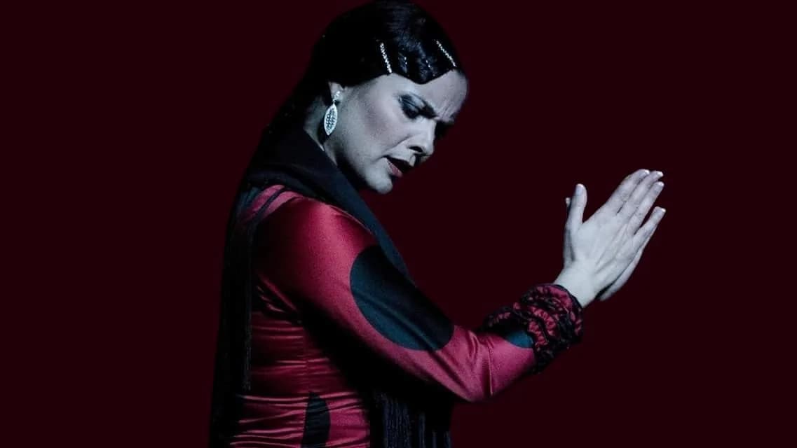 Retrato de una bailaora con manton rojo haciendo palmas, iluminada en tonos rojos en Casa Duende.