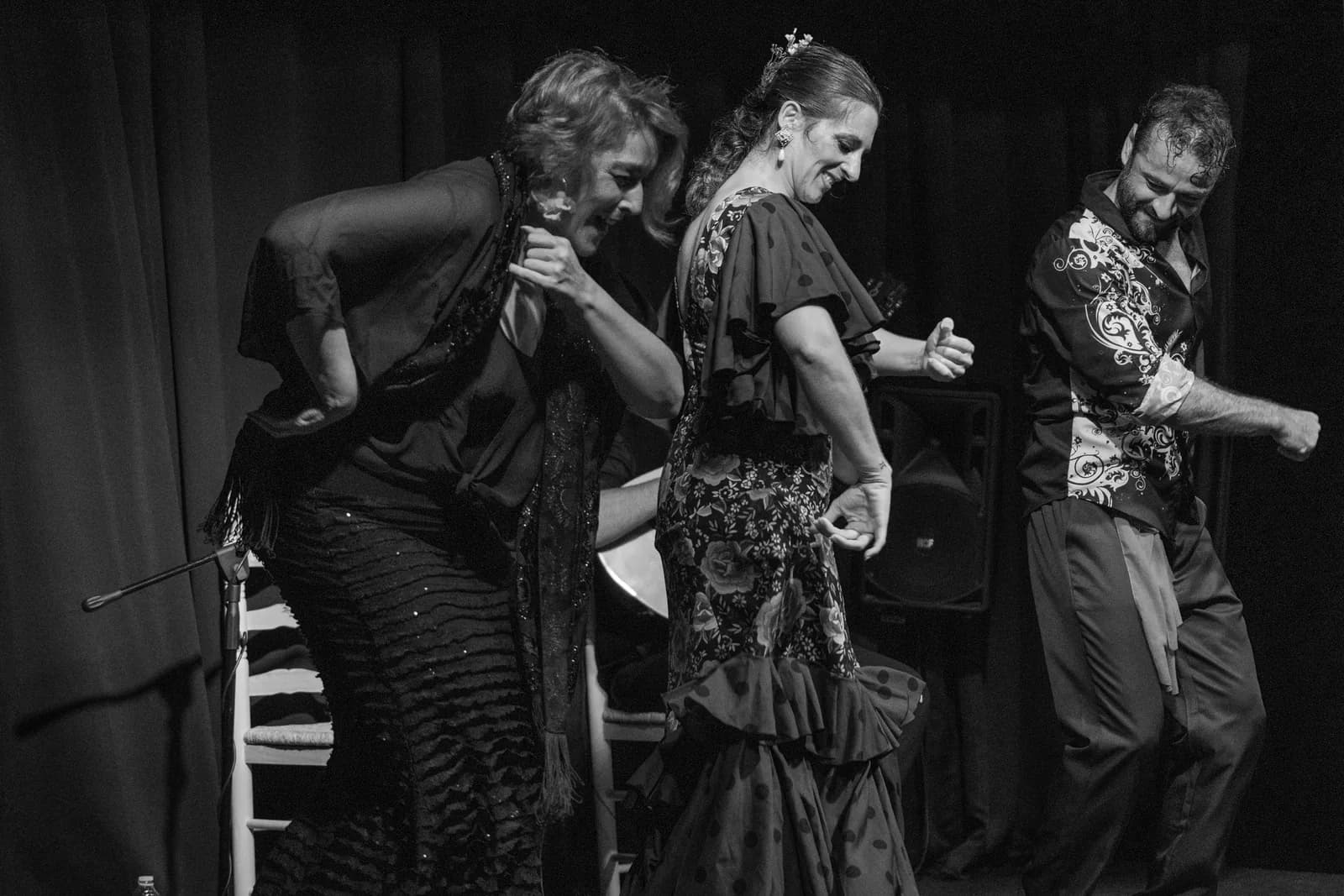 Tres bailaores actuando juntos sobre el escenario de Orillas de Triana, fotografia en blanco y negro.