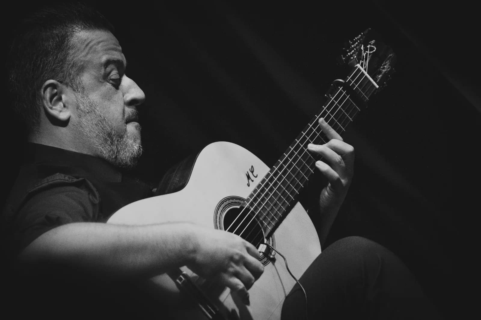 Guitarrista tocando la guitarra flamenca de cerca en Orillas de Triana, fotografia en blanco y negro.