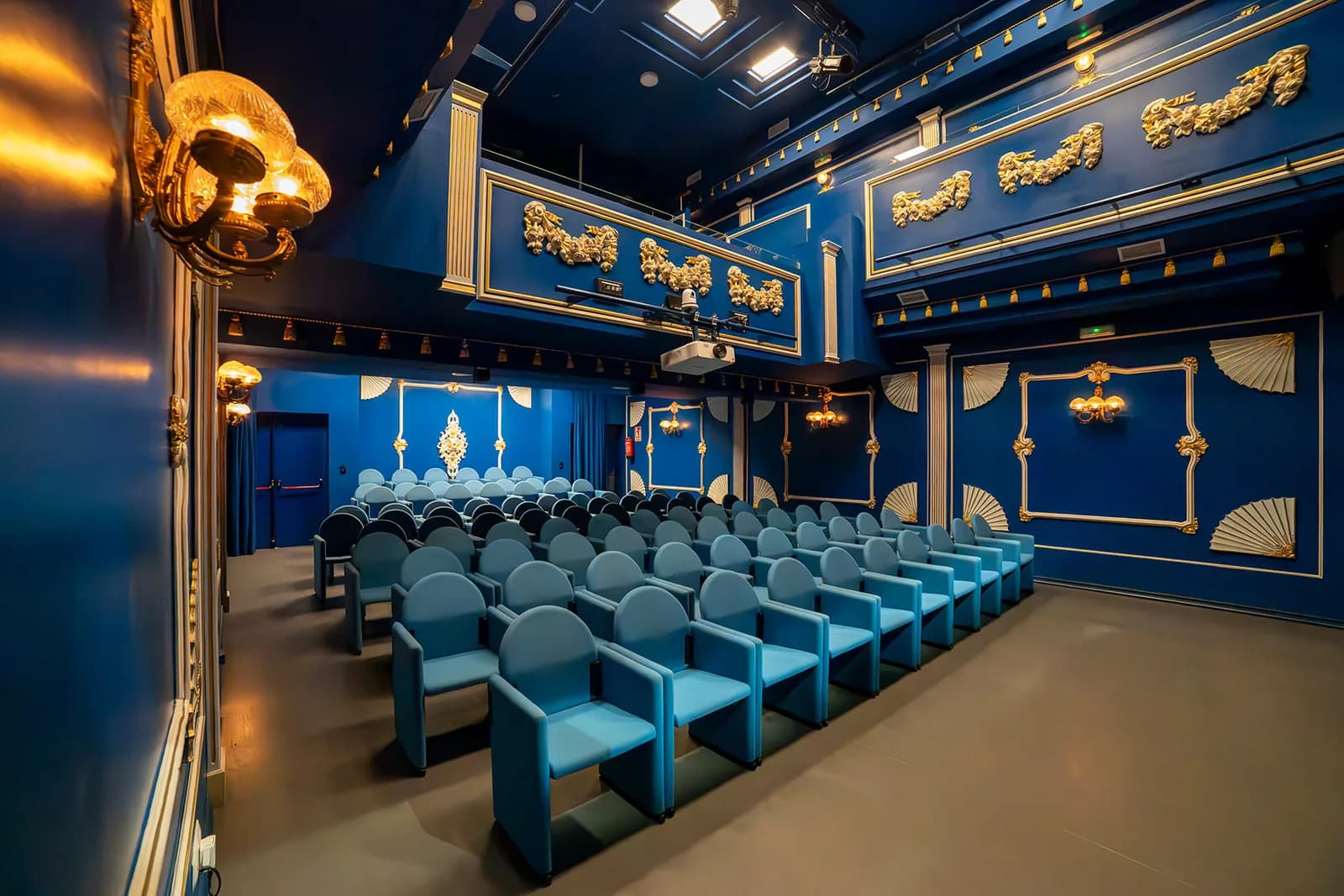 Interior de la sala azul y dorada del Teatro Flamenco Triana, vacia y vista desde el fondo hacia el escenario.