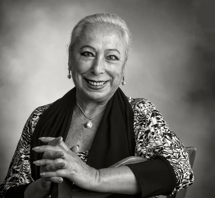 Retrato en blanco y negro de Cristina Hoyos, fundadora del Museo del Baile Flamenco, sonriendo con un manton sobre los hombros.